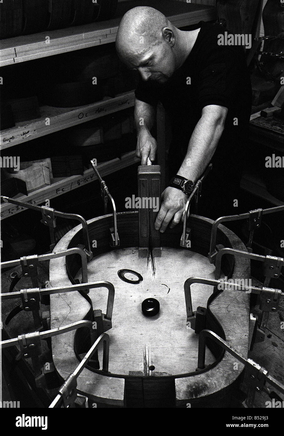 Lowden Gitarren In Bangor Co Down Northern Ireland Nov 99 das Holz bildet die Seite der Gitarre in Position George Lowden eingespannt ist zeigte ersten Anzeichen des Genies, als er war nur 10 1961 mit Hilfe von Co Down Postmeister machte er seine erste Gitarre aus Hartfaserplatte mit Nägeln für Bünde und Angelschnur für Zeichenfolge, jetzt ist er Vorsitzender des Lowden Gitarren ein Unternehmen der feiert ein Viertel eines Jahrhunderts in Geschäft, eine der besten Gitarren der Welt Stockfoto