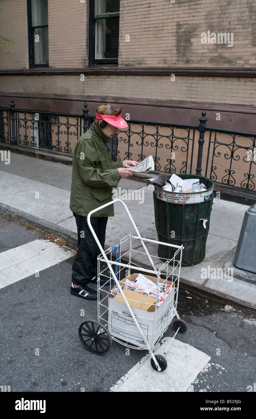 Frau liest Papier aus Straße Abfallbehälter Stockfoto