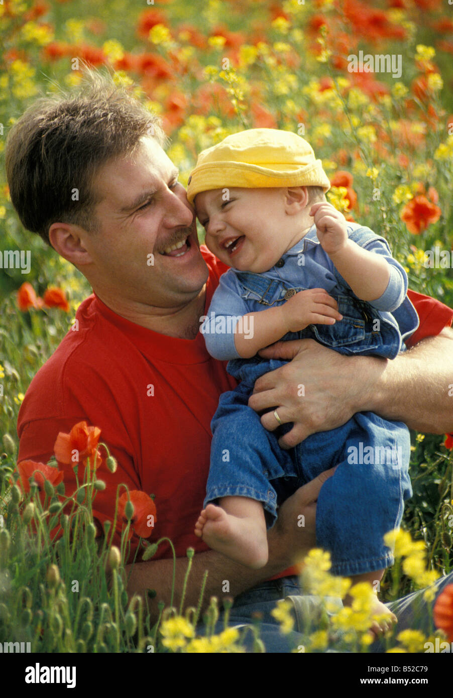 Papa Spaß mit seinem Baby im Mohnfeld Stockfoto