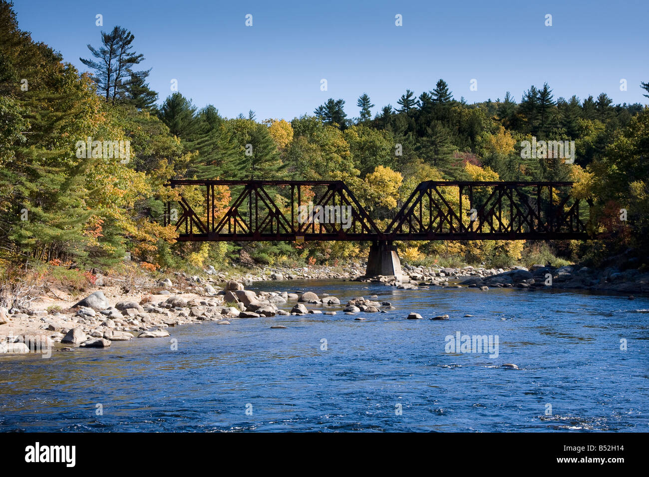 Eine alte Eisenbahnbrücke mit einer Kulisse aus fallen Laub Kreuze der Pemigewasset River in Plymouth, New Hampshire Stockfoto