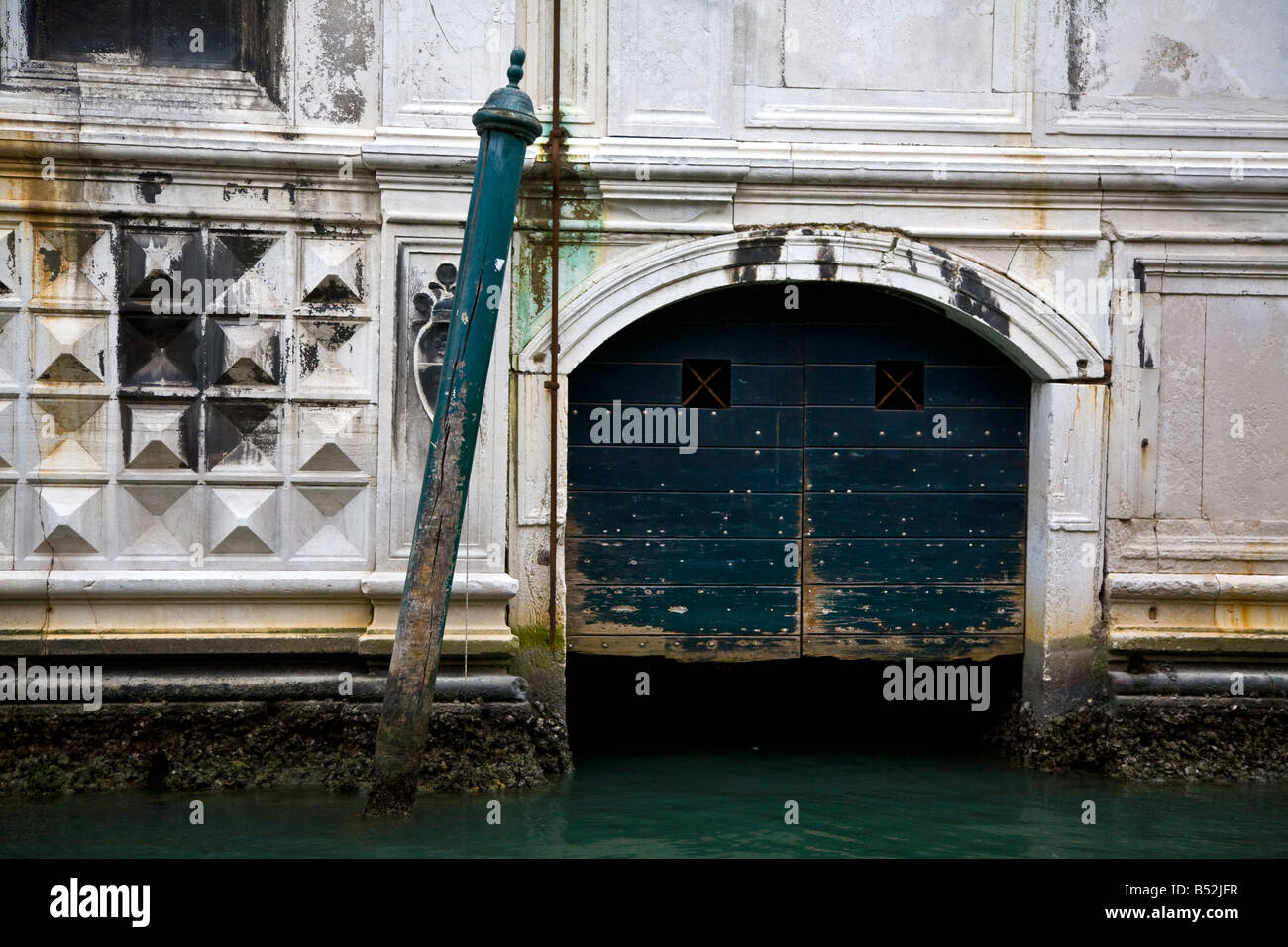 Venedig-Kanal mit schiefen barber Pole und weißen Gebäude Detail Tür Stockfoto