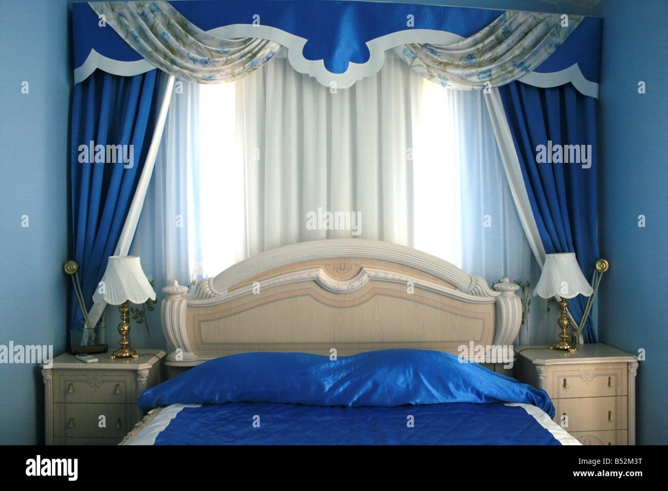 Blaue modische Schlafzimmer mit schönen Vorhängen Stockfoto