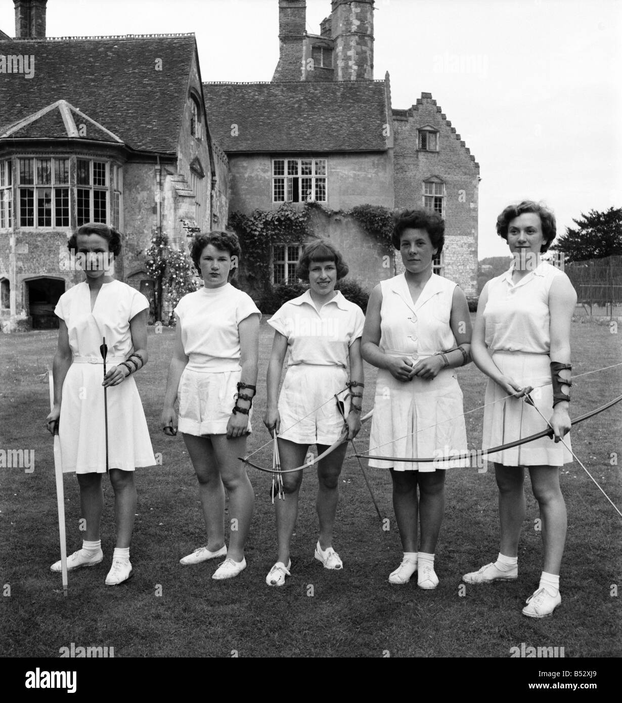 Bisham Abbey körperliche Erholung besichtigt. Eine Gruppe von Frauen auf dem Rasen vor der Abtei bekommen ein wenig Bogenschießen üben. Stockfoto