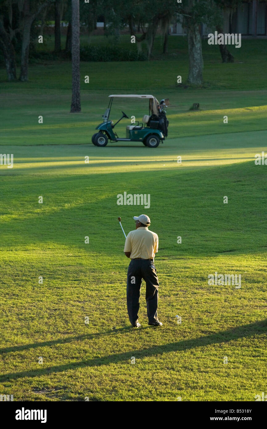 Golfer und Golf Cart auf einem Golfplatz in Zentral-Florida am späten Nachmittag, Grenelefe, Haines City, Vereinigte Staaten Stockfoto