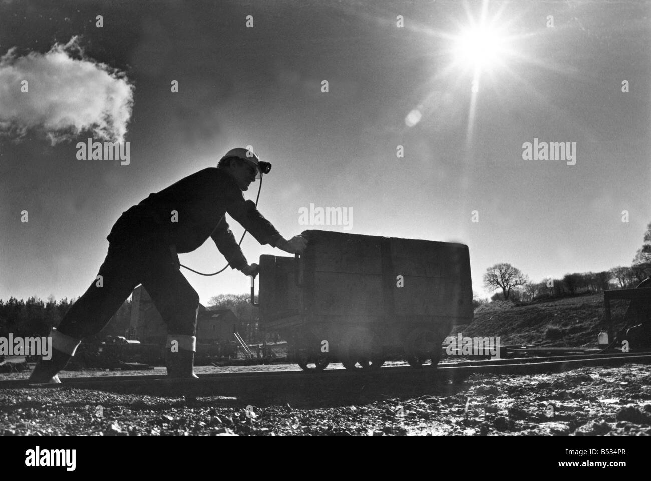 Ein Bediensteter, gekleidet wie ein Bergmann schieben eines Drehgestells Beamish Museum Stockfoto