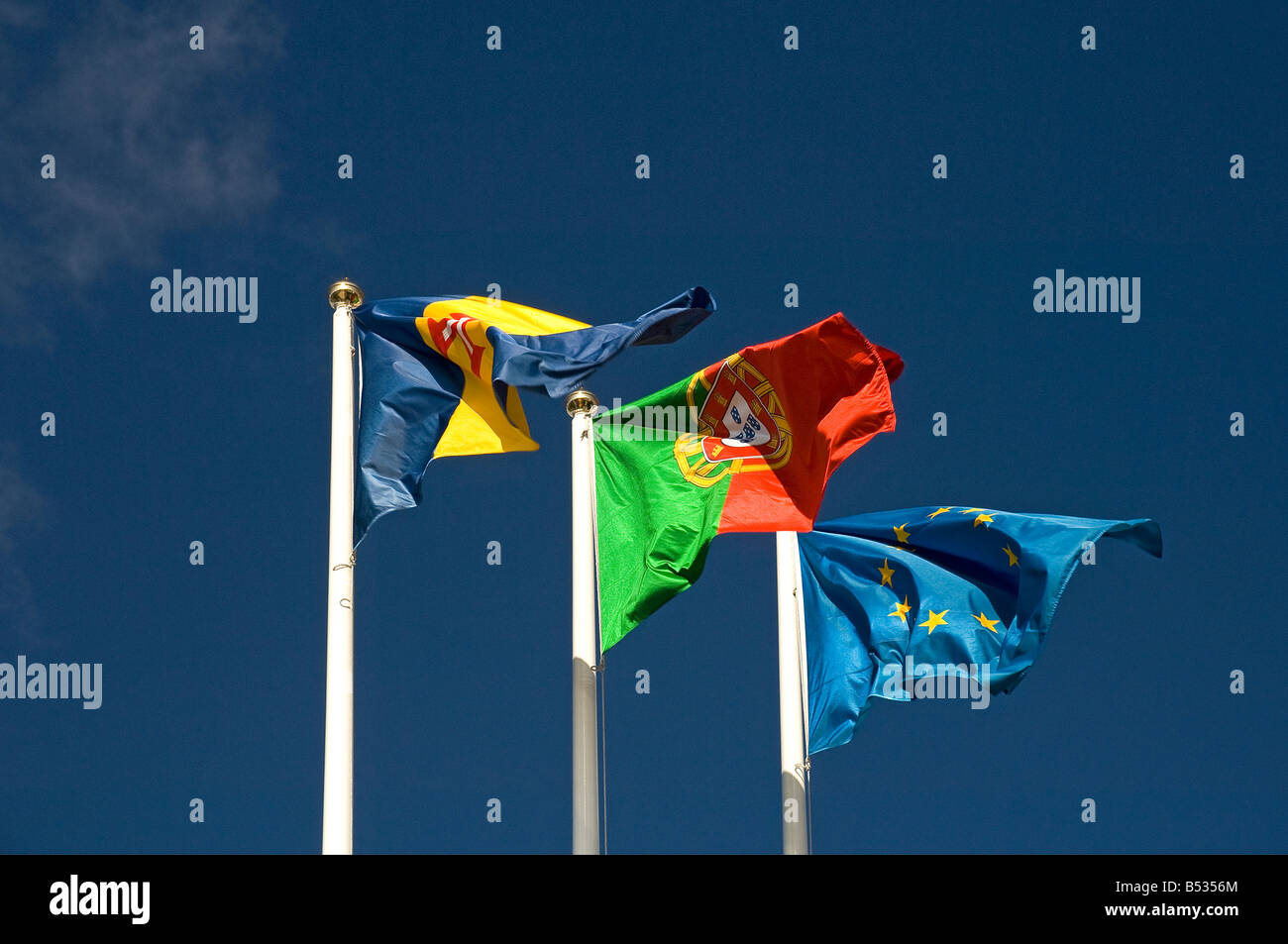 Flaggen, die gegen den blauen Himmel fliegen Madeira Portugal und die Europäische Union Stockfoto