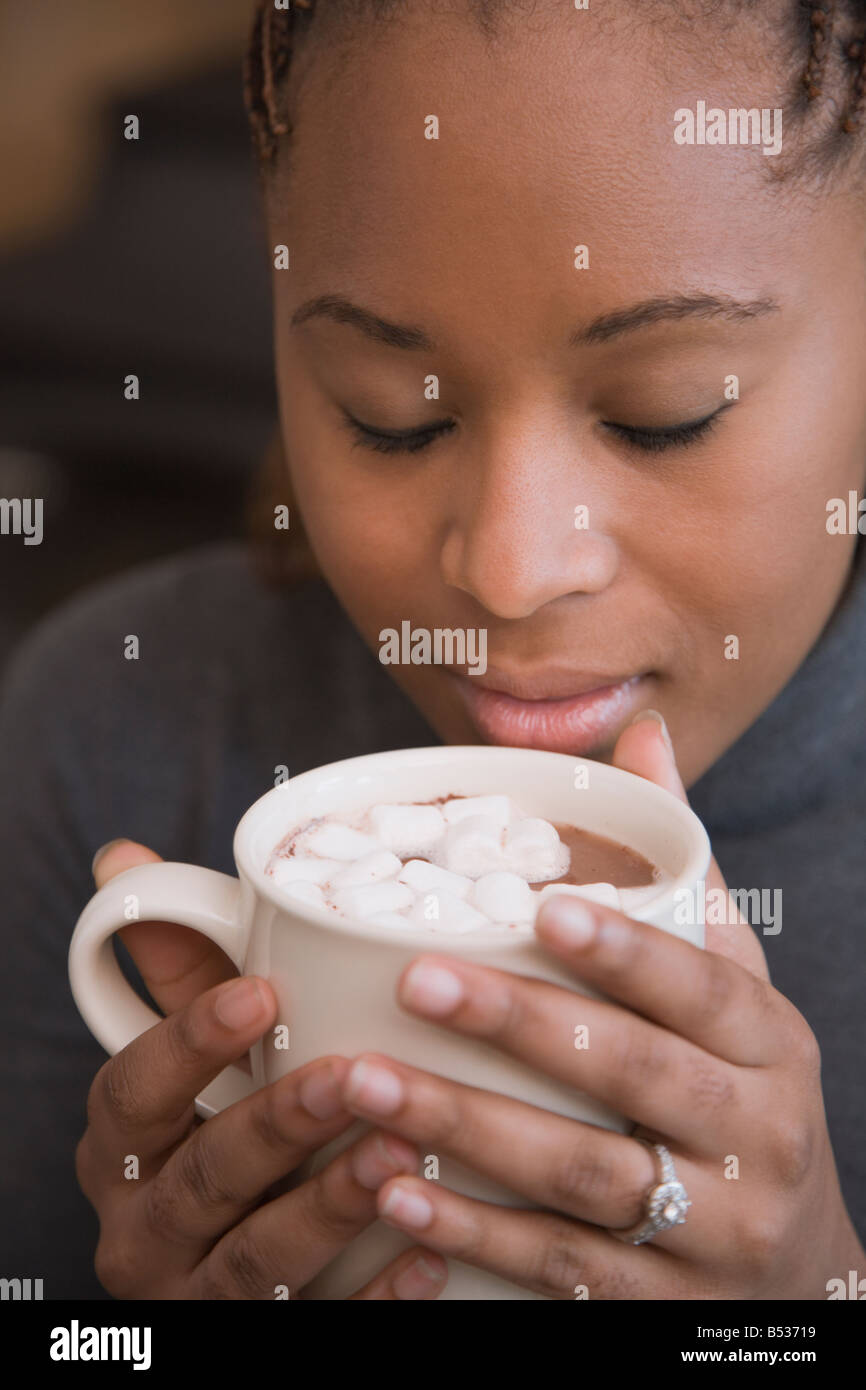 Afrikanerin, die duftenden Tasse heißen Kakao mit marshmallows Stockfoto