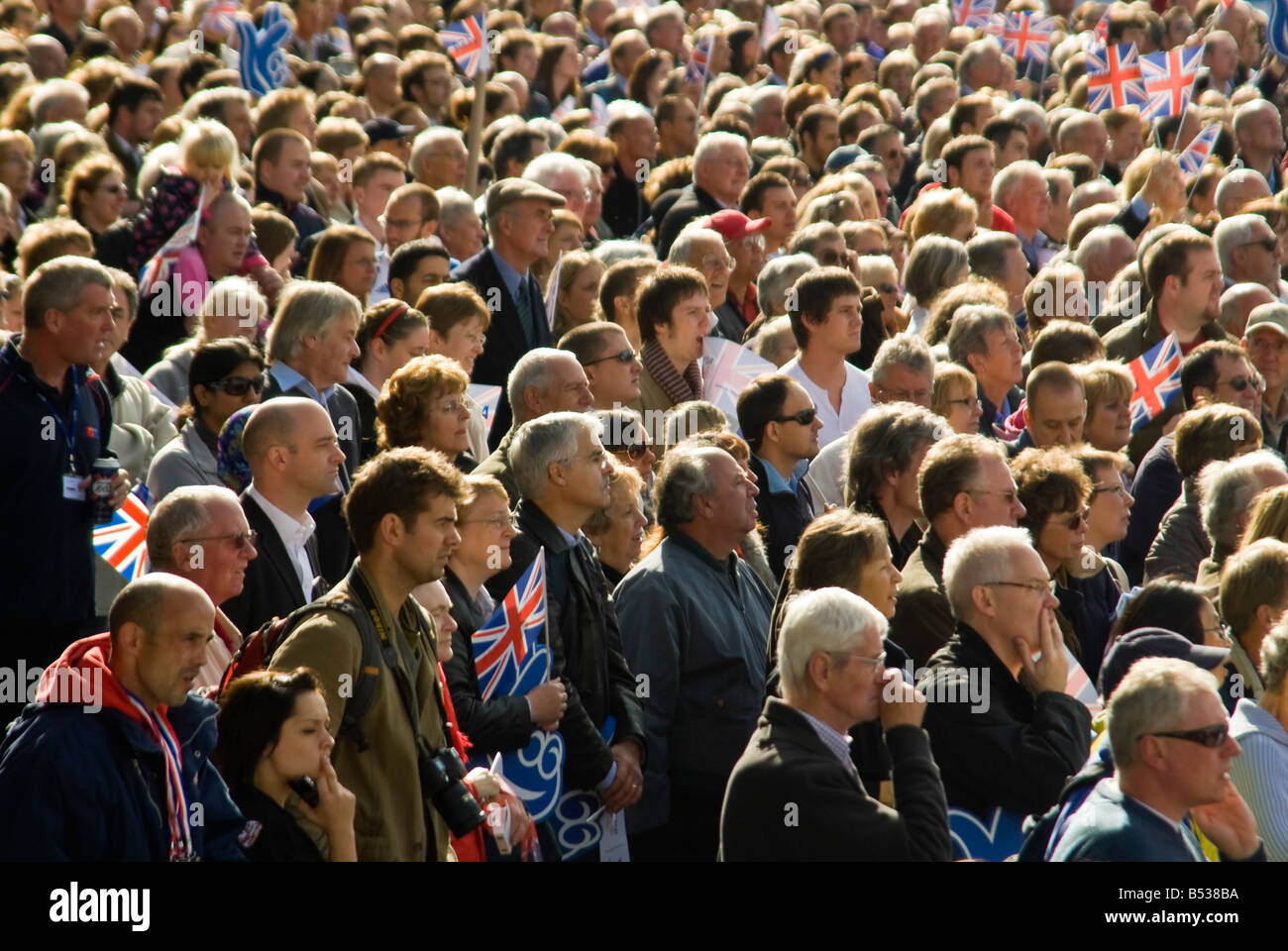 Horizontale erhöhte schließen sich eine große Gruppe von Menschen versammelten sich gemeinsam in eine Richtung an einem sonnigen Tag suchen. Stockfoto