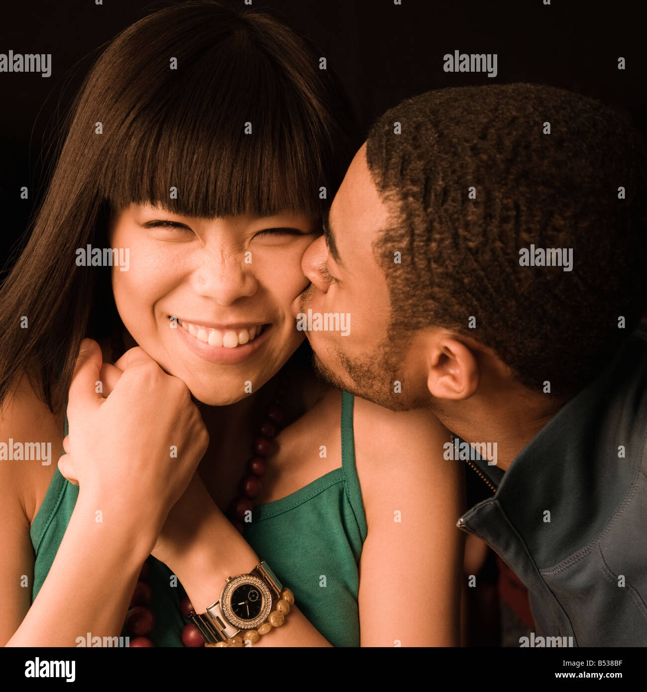 Afrikanischer Mann küssen asiatische Freundin Stockfoto