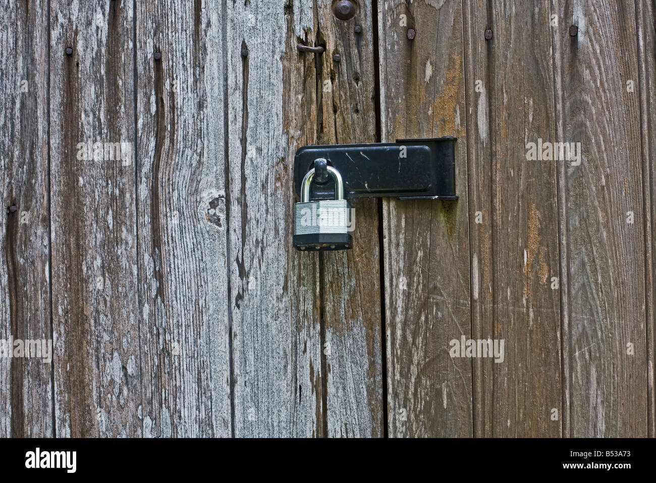 Metall-Sperre auf einer alten verwitterten Holztür Stockfoto