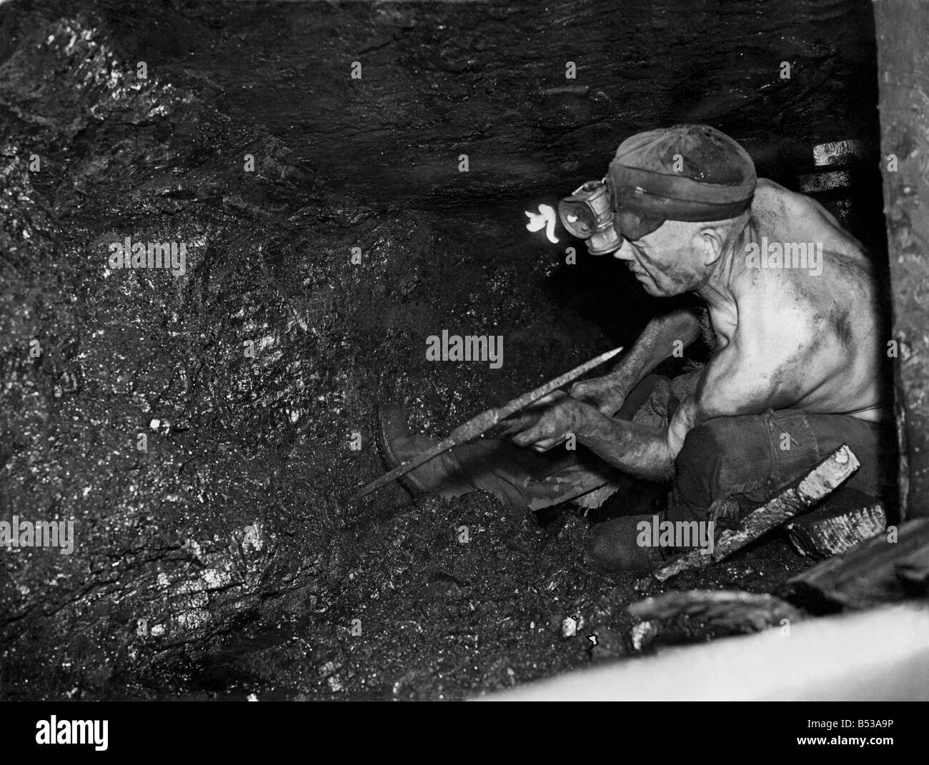 Kohleminen u-Szenen. Norton Hill "Zeche", Somerset. Ernest "Knowles," 40 Jahre "Bergmann", wogenden Kohle. März 1946 Stockfoto