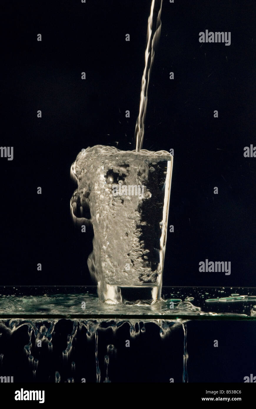 überlaufende Wasser Glas Stockfoto
