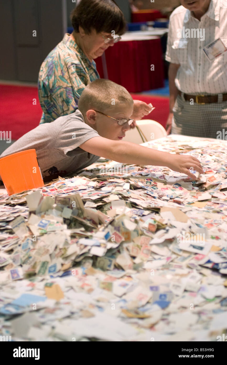 Junge Briefmarkensammler intensiv durchsucht Briefmarken zum Verkauf an einem Stand auf der American Philatelic Society Stempel in Hartford, CT. Stockfoto