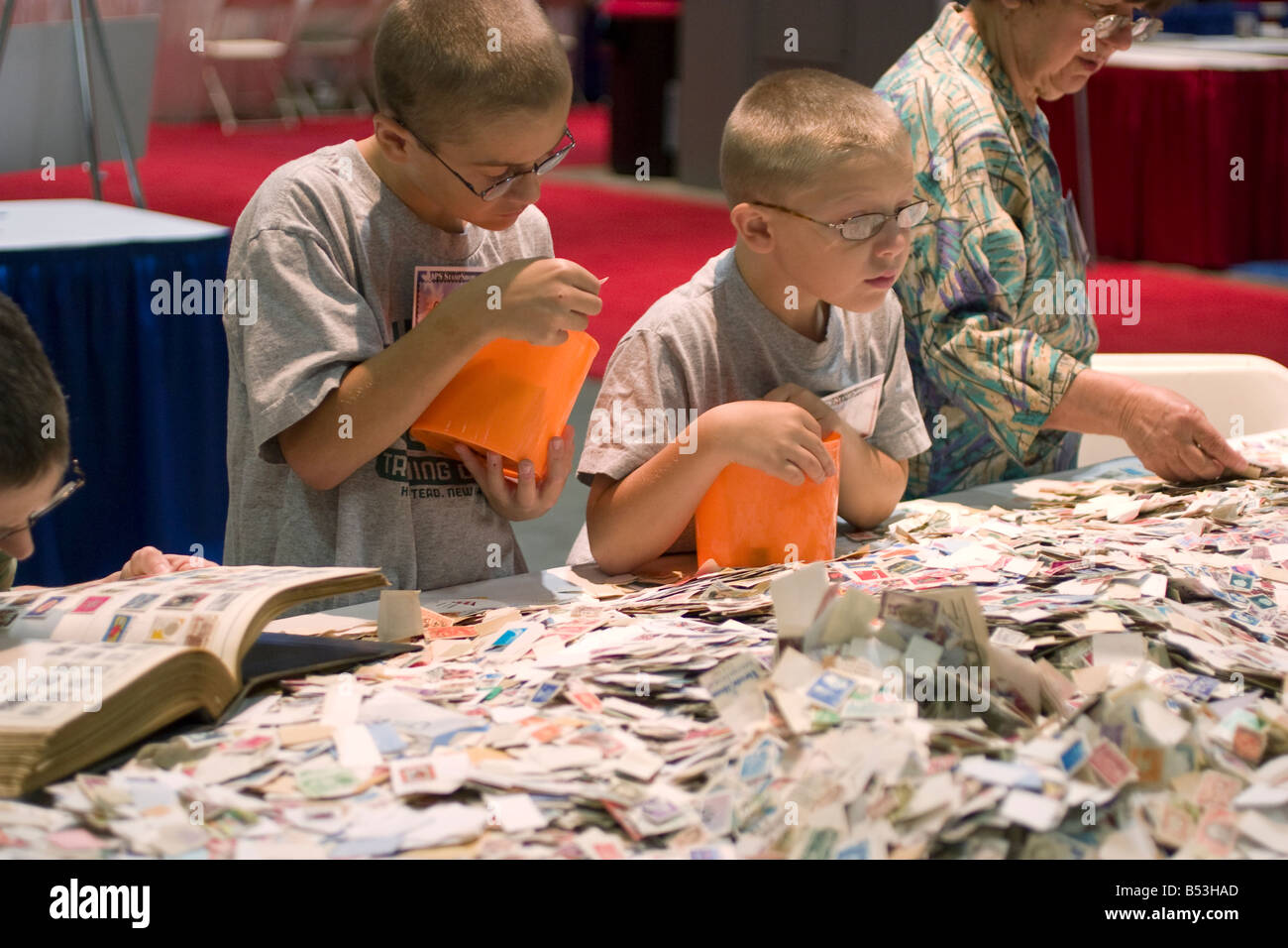 Junge Briefmarken Sammler intensiv durchsucht Briefmarken zum Verkauf an einem Schnäppchen-Stand auf der American Philatelic Society Stempel in Hart Stockfoto