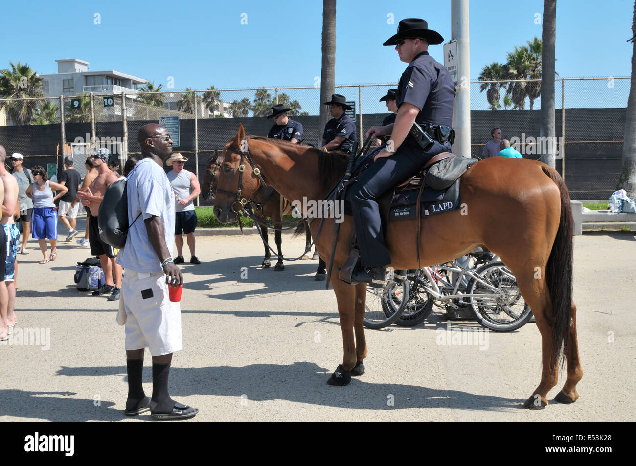 Afrikanisch-amerikanischer Mann hat einen netten Plausch mit einem Pferd Offizier von der Los Angeles Police Department oder LAPD montiert Stockfoto
