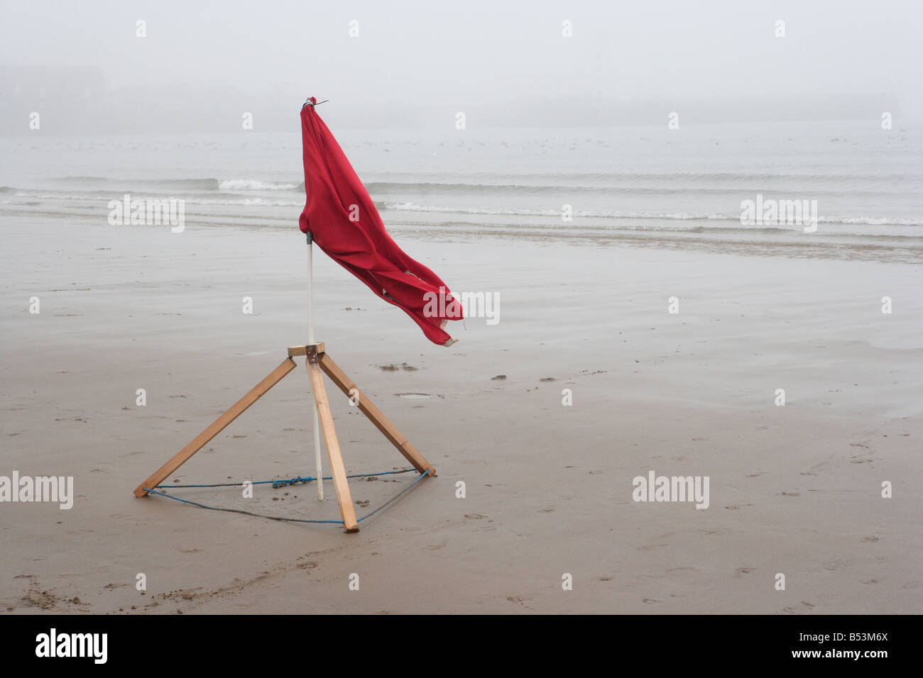 Leuchtende rote Warnfahne am unberührten Leblon-Strand mit Meer im