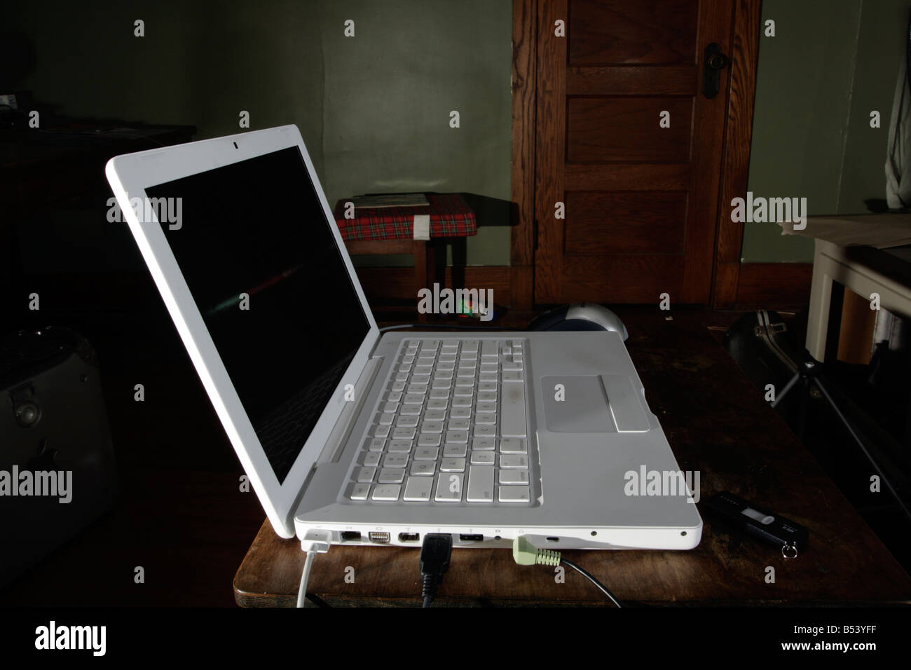 Weißes MacBook Laptop-Computer im abgedunkelten Raum. Stockfoto