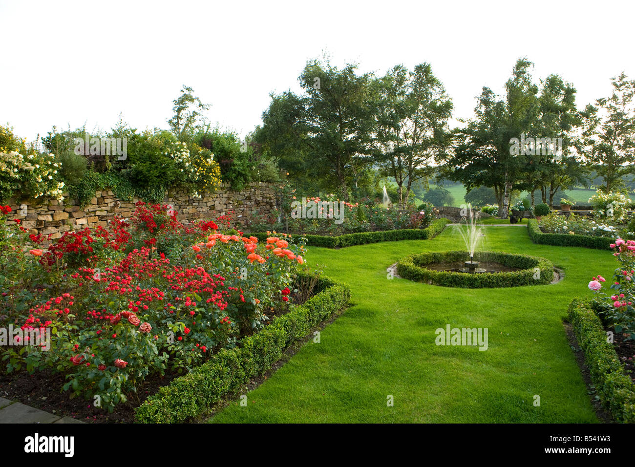 Ein Wasserspiel mit Springbrunnen in einem formalen Rosengarten Stockfoto
