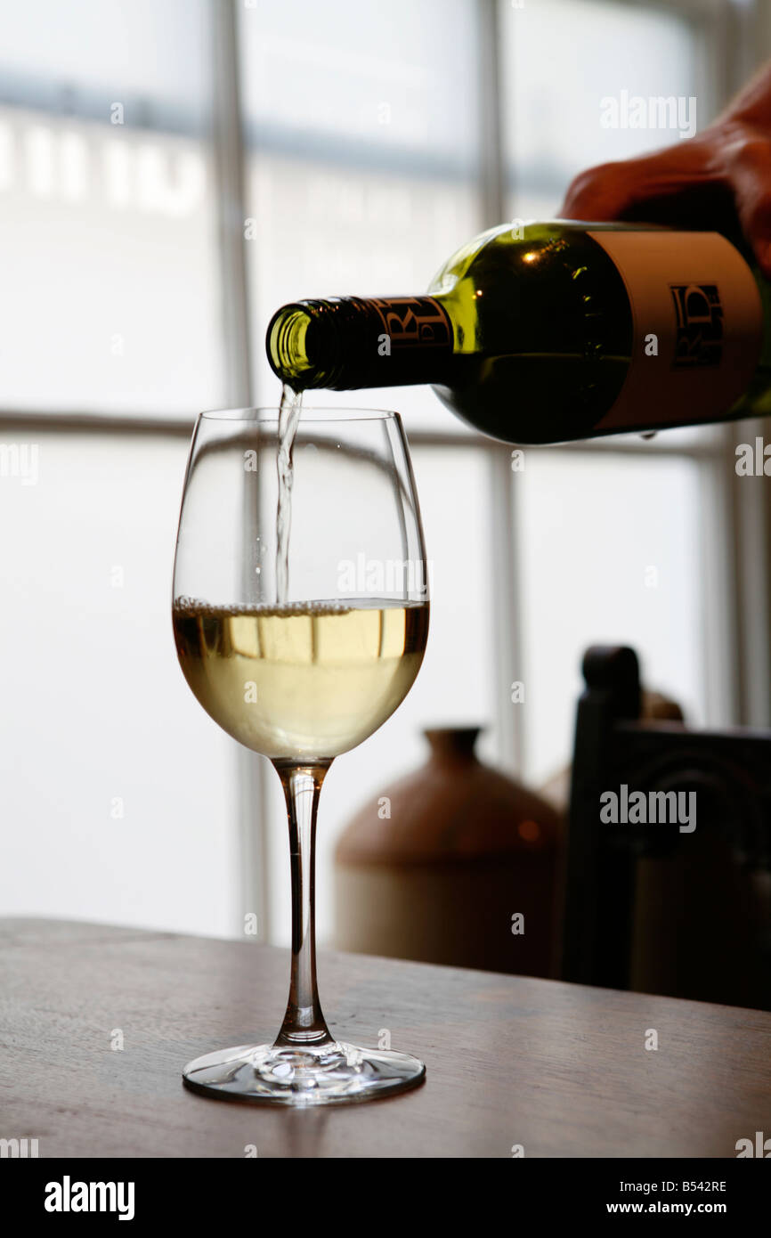 Ein Glas Weißwein gegossen Stockfoto