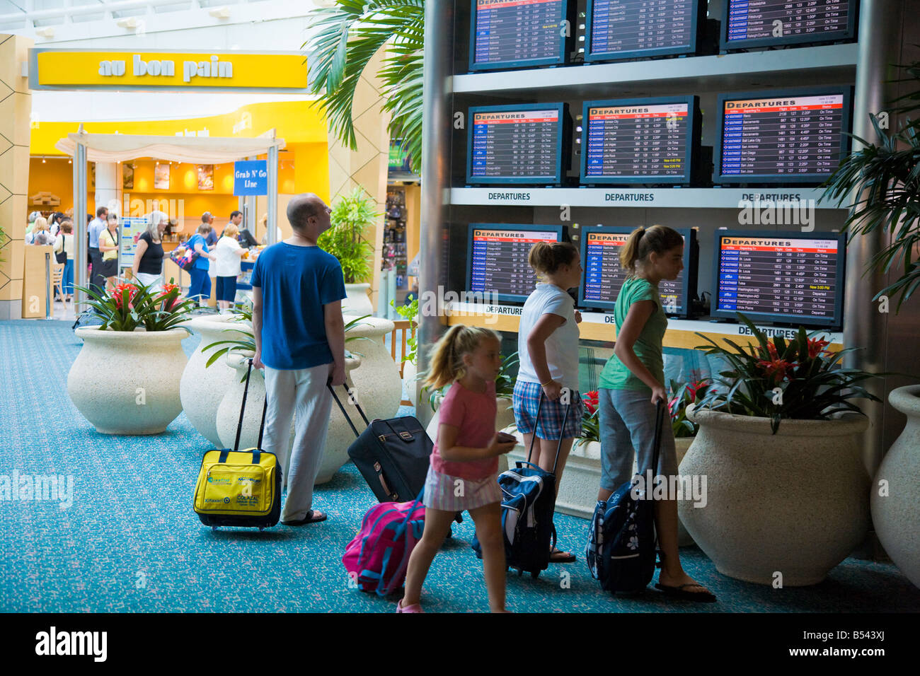 Reisende, die den Ankunfts- und Abflugplan am Orlando International Airport sehen Stockfoto