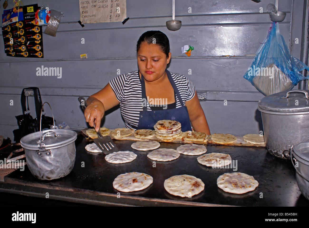 Frau Kochen Pupusas in einem Pupuseria, San Salvador, El Salvador Stockfoto