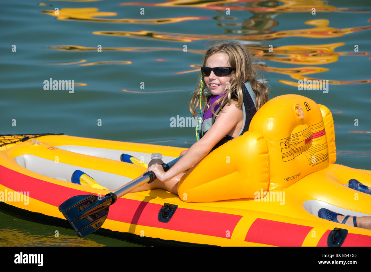 Mädchen Preteen Kajak leuchtenden Farben gelb Kajak Blauwasser Sommerurlaub Stockfoto