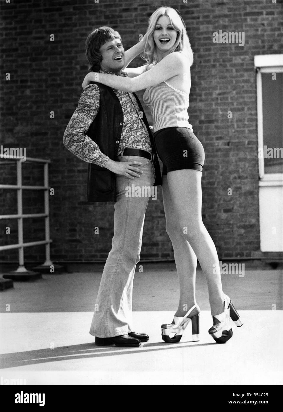 Mode - 70er Jahre. Die zweigeschossige Schuh Geschichte Ö für das Mädchen mit mehr als einem Freund es ist etwas Neues in der Modeszene: zwei geschossigen Hochhaus Schuhe. Sie können eine bescheidene 4 Zoll Ferse und 2 Zoll Plattform tragen, mit kleiner Kerl. Aber wenn sie mit ihrem Over-six-footer dating geht sie jetzt kann hinzufügen, ein weiteres 2 Zoll ihre Sohle und Absatz. Die neuesten bebauten Schuhen gehen höher als je zuvor mit Hilfe von eine zusätzliche Schicht von Sohle und Absatz mit jedes Paar Schuhe verkauft. In fünf verschiedenen Ausführungen dieser Monster-Schuhe zu verkaufen für £17,50 (teuer, aber Sie sind immer zwei Paare!) bei Derber Stockfoto