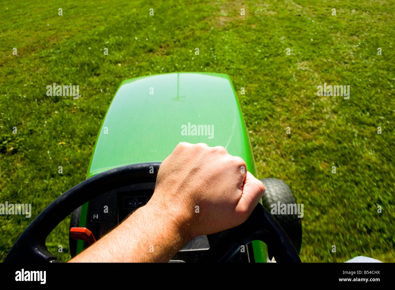 First-Person-Perspektive der Mähen des Rasens auf einem John Deere Reiten Rasenmäher. Stockfoto