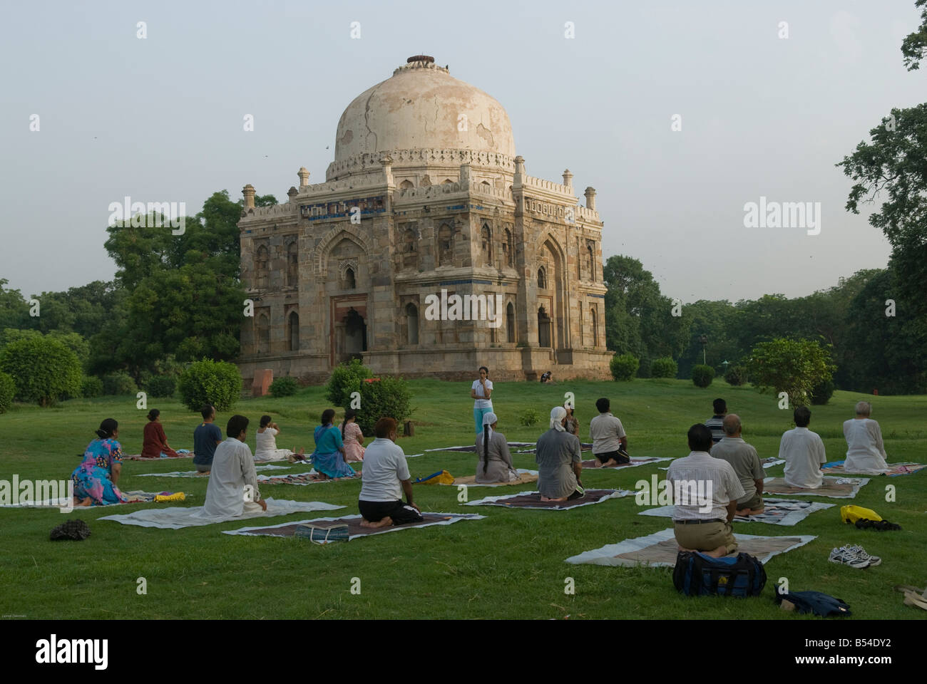 Menschen bei einer Yoga-Klasse vor der Bara Gumbad oder große Kuppel in Lodhi Gärten in Neu-Delhi. Stockfoto