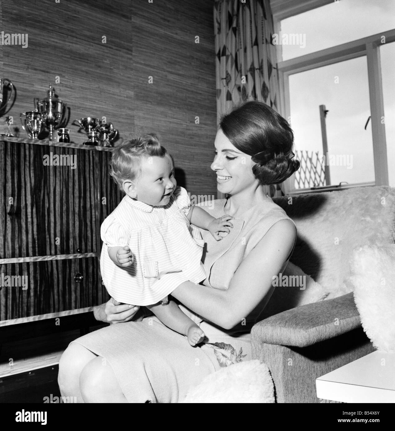 Zwanzig vier Jahre alten Modell und Schauspielerin Madeleine Mono von Hampstead, ist die Mutter von vier schöne Kinder--Gail 6, Louise 4, Craig 2 und Grant 8 Monaten. Madeleine Mono fotografiert an ihre Kirche zu montieren, Hampsted Haus mit ihrem Baby; Juni 1960; M4427-007 Stockfoto