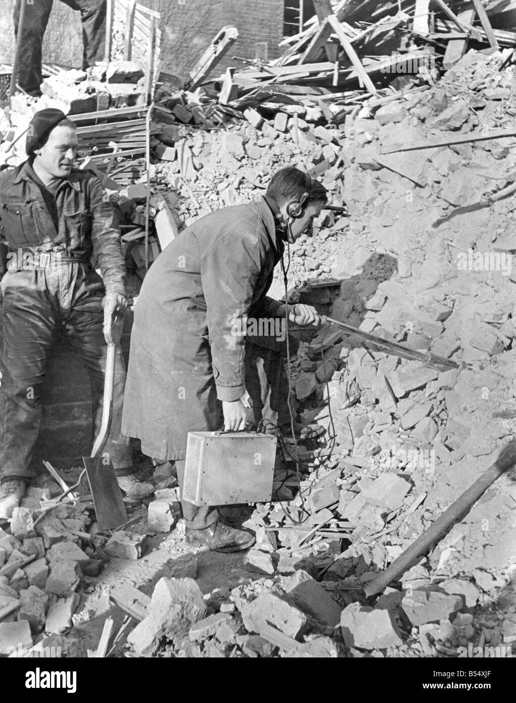 Zweiter Weltkrieg: Krankenhaus. Wünschelrute für Radium unter den Trümmern des Marie-Curie-Krankenhaus, Hampstead. Herr E.E. Smith von der N.P.L. mit einem Instrument, bekannt als das gackernde Huhn. Der Behälter war heut wieder intakt aus in der Nähe dieser Stelle. Februar 1944-P011563 Stockfoto