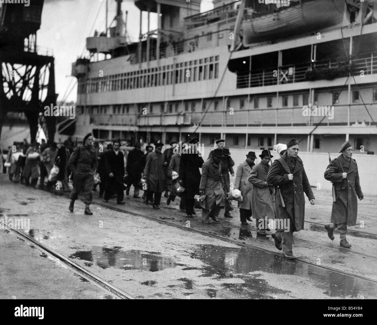 Flüchtlinge aus den niederländischen Kolonien entlang der Uferstraße unter Eskorte der niederländischen Soldaten marschieren.  
 Oktober 1945  
 P012059 Stockfoto