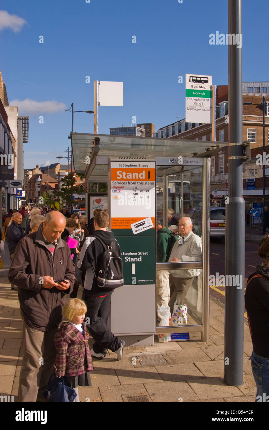 Im Stadtzentrum von Norwich, Norfolk, Großbritannien mit einem Bus an der Bushaltestelle wartenden Personen Stockfoto