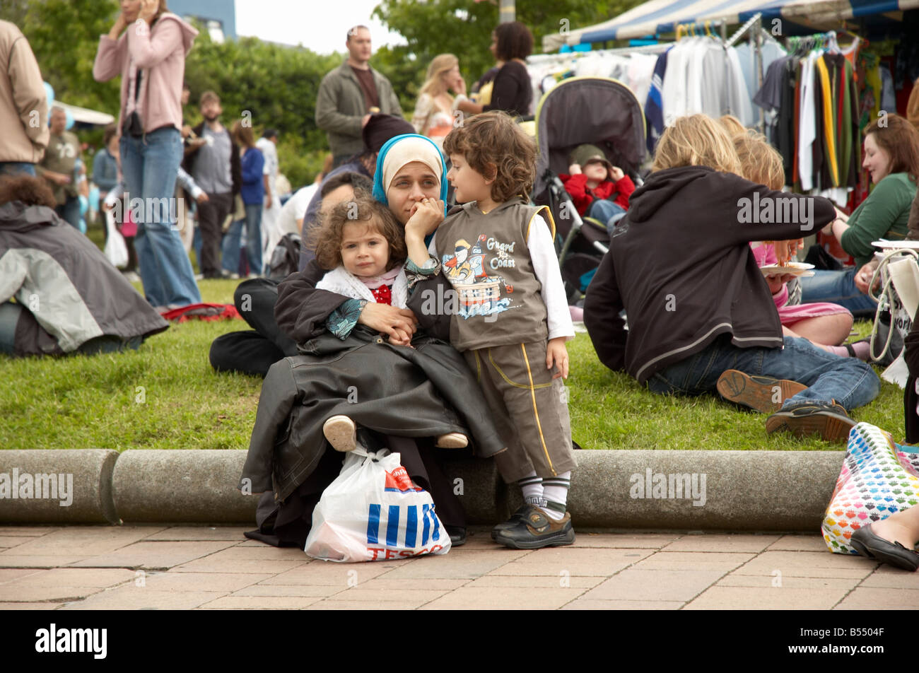 Die muslimische Frau und ihre Kinder beobachten die Cowley Straße Karneval in Oxford Stockfoto