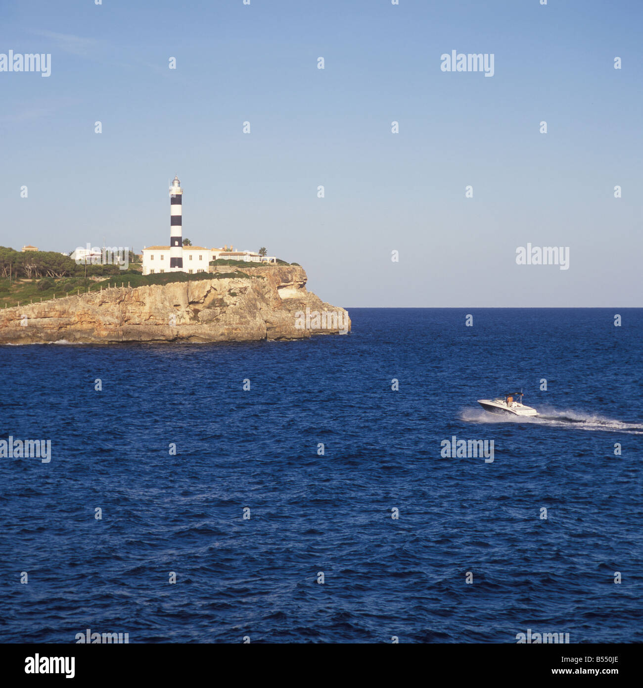 Motorboot Appraching Eingang mit Leuchtturm an der geschützten Bucht Ankerplatz von Porto Colom Ostküste Mallorca Mallorca Stockfoto