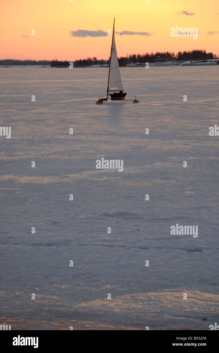 Eine Eissegelboot gleitet in Ufer auf die Charlottetown Harbour mit einem goldenen Sonnenuntergang im Hintergrund Stockfoto