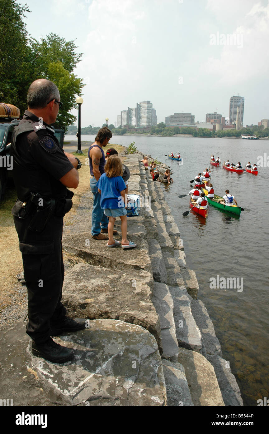 OPP Offizier Uhren suchen, wie Kanufahrer auf dem Ottawa River nehmen. Stockfoto