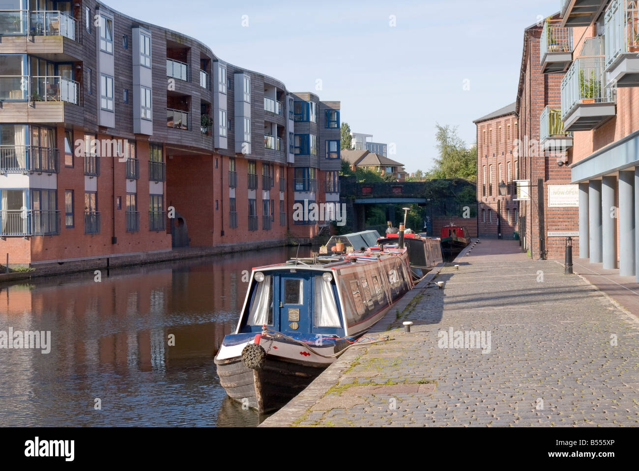 Apartments mit Blick auf den Kanal in Birmingham mit "Narrow Boats" vor Anker auf dem Treidelpfad Stockfoto