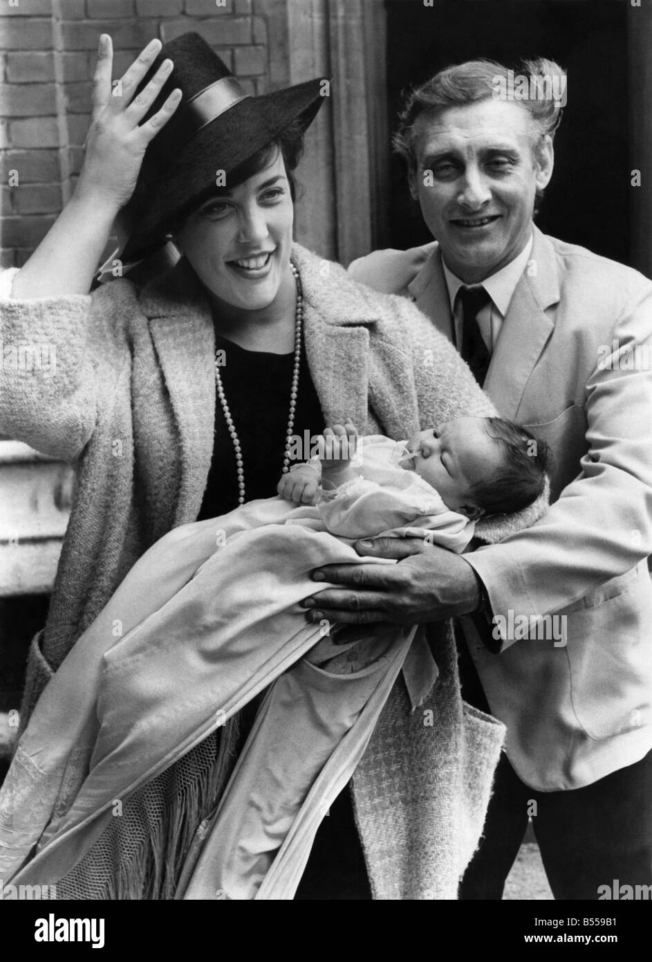 Spike Milligan und Frau mit Hut Schwierigkeiten mit Baby Jane Fionulla nach der Taufe in St. Albans r.c. Kirche, Schleifstein. Juni 1966 P011410 Stockfoto