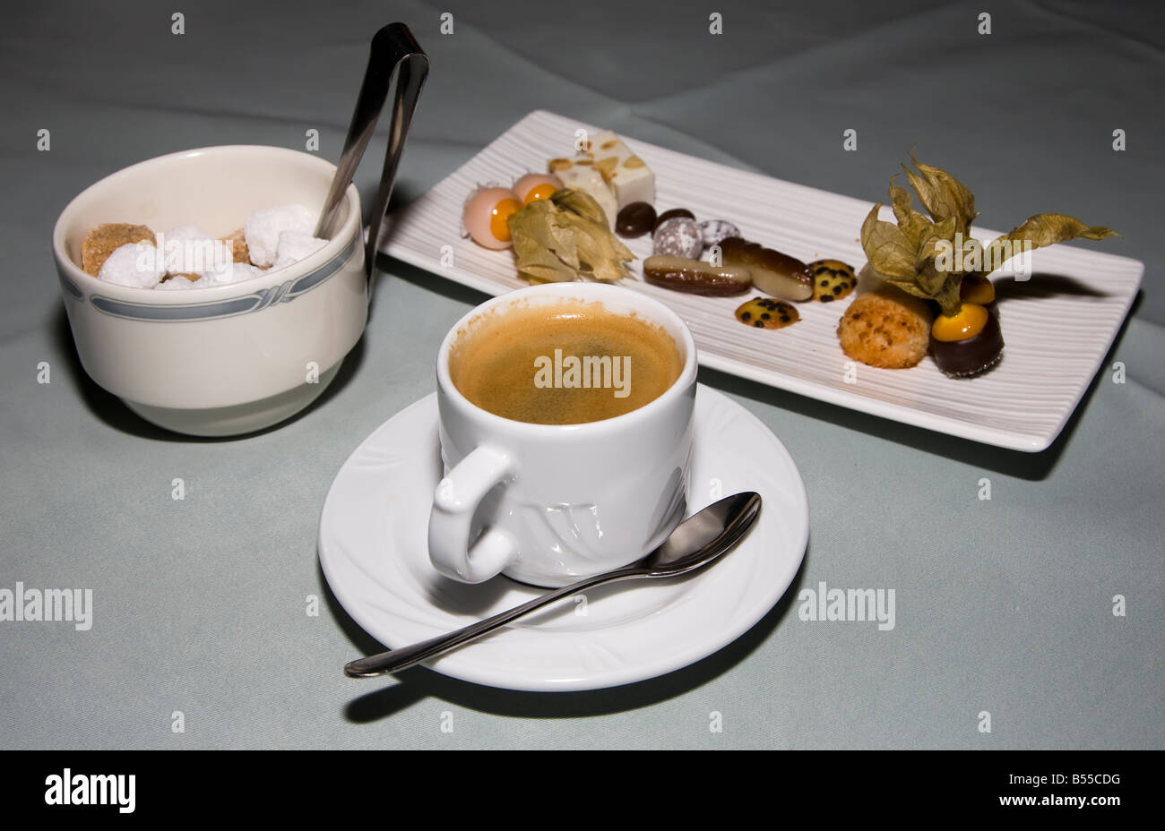 Schwarzer Kaffee mit Zucker Klumpen in Schüssel mit Zange und Süßigkeiten auf Tabelle Belgien Stockfoto