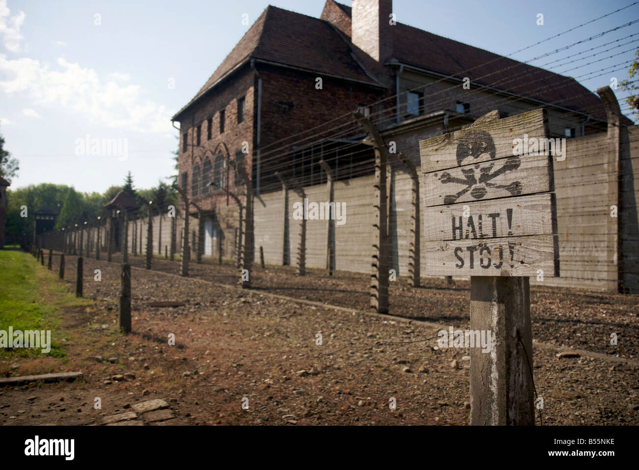 Warnung-Stop-Schild mit Schädel & Knochen Symbol vor Stacheldraht elektrifizierten Zaun im ehemaligen Konzentrationslager Auschwitz ich Stockfoto