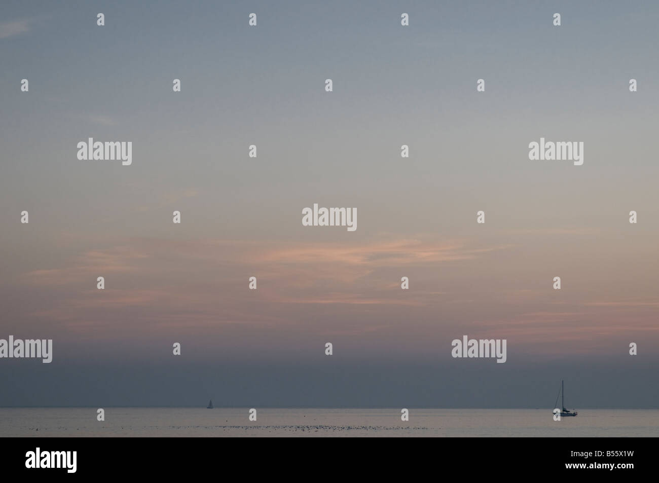 Dämmerung über Cardigan Bay West Wales Yachten auf dem flachen ruhigen Meer, UK Stockfoto