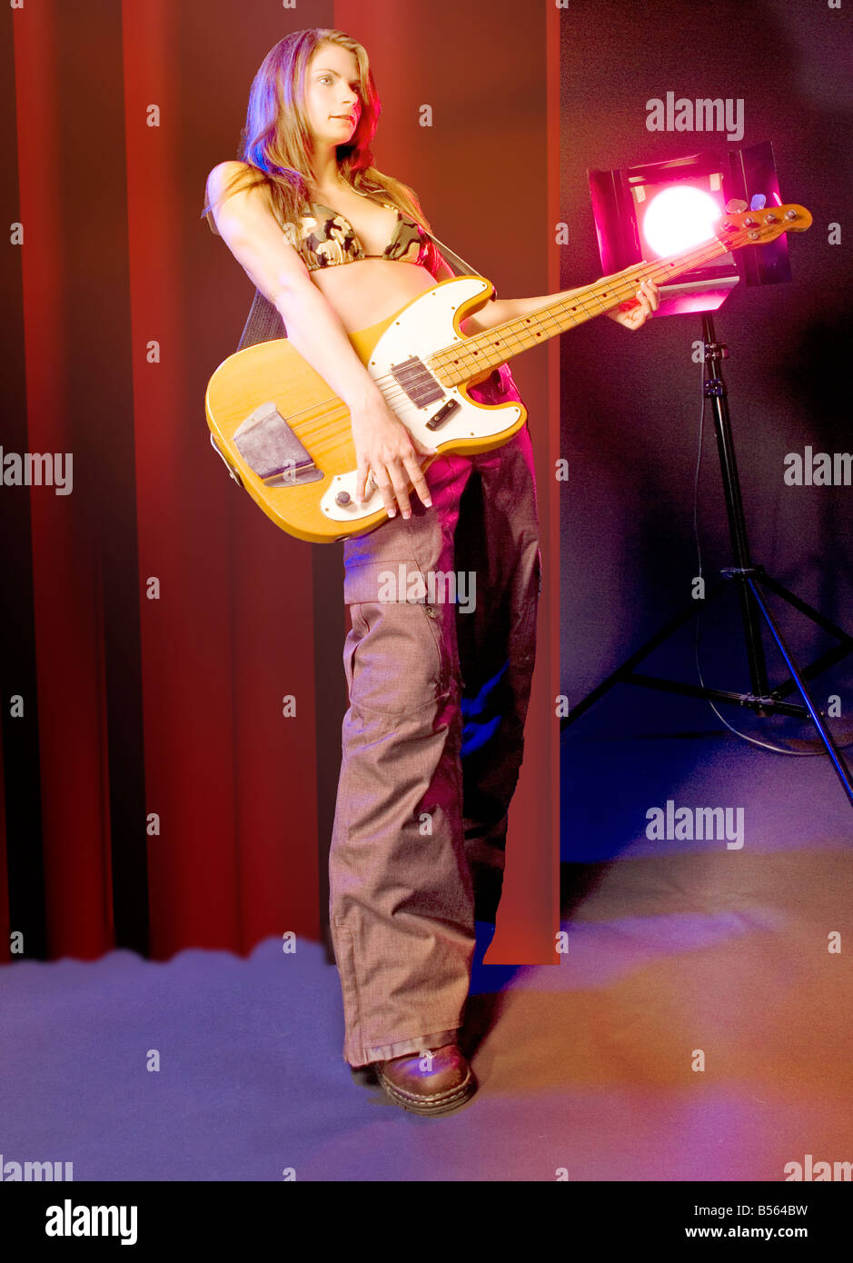 Kaukasische Frau 30 bis 35 Jahren spielt Bass-Gitarre auf der Bühne USA Stockfoto