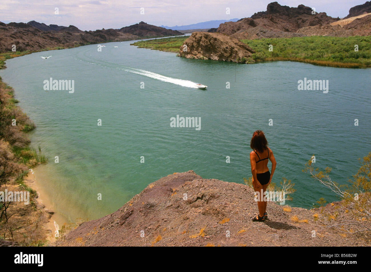 Frau Tourist schaut zu, wie Schnellboote die Oberfläche des Colorado River flussaufwärts aus Lake Havasu, Arizona, USA überfliegen Stockfoto