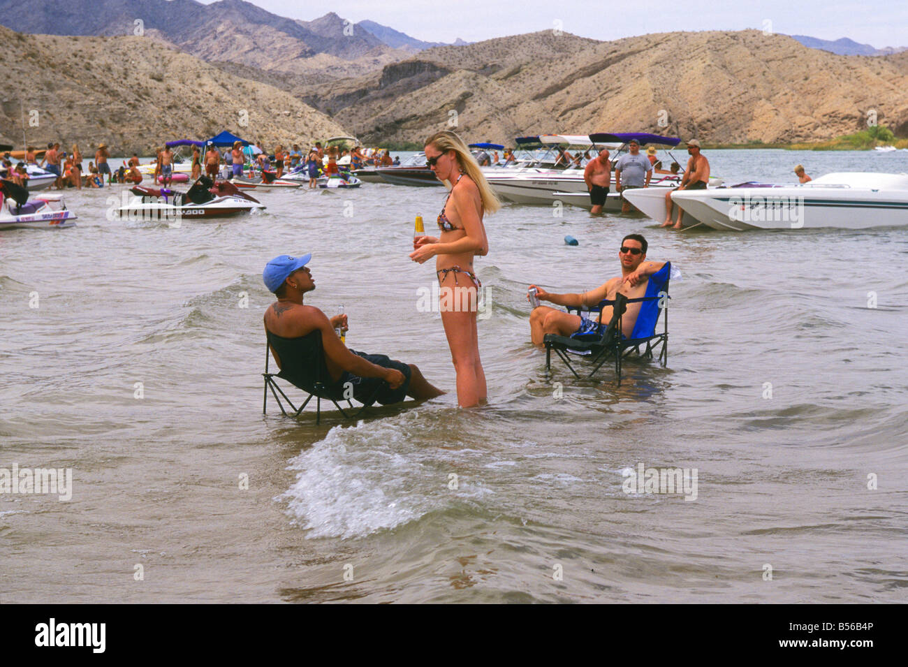 Menschen trinken Bier und entspannen Sie sich in Liegestühlen und um ihre Boote und jet-Skis in den Untiefen des Lake Havasu. Arizona, USA Stockfoto