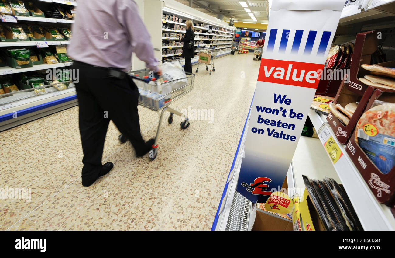 Tesco Wert: ein Geschäftsmann mit Einkaufswagen eine gekühlte Gang hinunter von Pizza und Pasta. Stockfoto