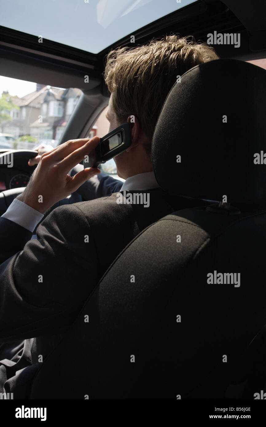 Ein Mann mit einem Handy im Auto Stockfoto