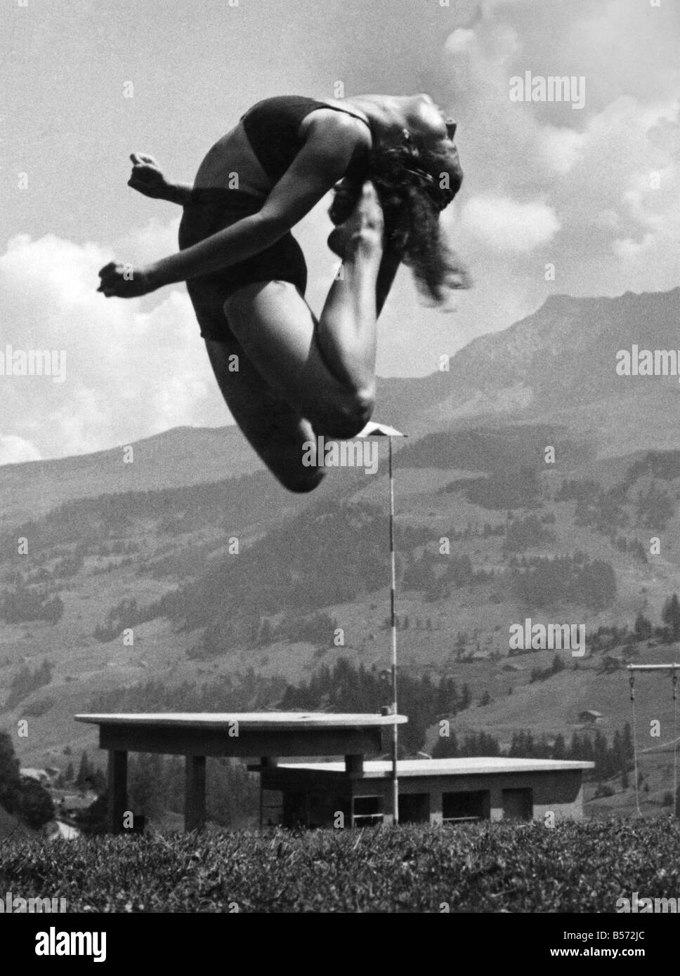 Franline Ruth Bittmann, Basel, Rhythmus-Experte, scheint gesprungen sind, wie hoch wie der Berg von 10.000 Fuß, wilde Strubel im Hintergrund dieses Bildes über dem berühmten Schwimmbecken in Adelboden im Berness Oberland genommen. April 1938 P010742 Stockfoto