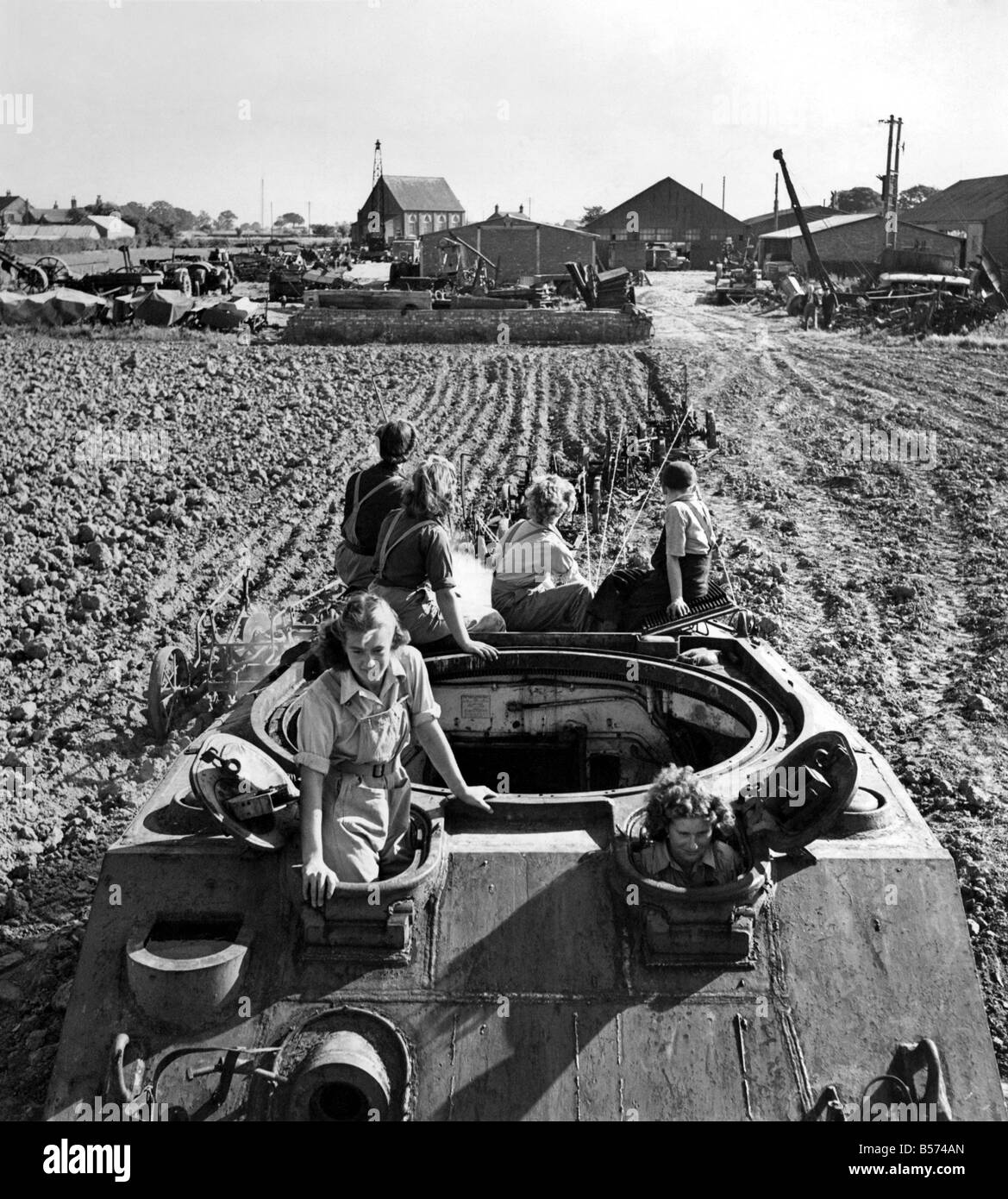 Landwirtschaft-Ingenieur und Unternehmer, Herr R. H. Crawford von Frithville, in der Nähe von Boston, Lincs, ein Ex-Alamein Schlacht vernarbt gekauft hat Sherman-Panzer zu pep herauf seine landwirtschaftliche Verträge. Dieser riesige Panzer von gekoppelten 90 PS Dieselmotoren angetrieben ist wieder, diesmal in der alle wichtigen Kampf für die Nation Brot kämpfen. Mädchen die Frauen Landheer in Carrington, die eingeladen waren die ersten Versuche, gründlich genossen ihre erste Fahrt auf der Sherman, sondern waren auch sehr daran interessiert, das Experiment. Die Sherman Pflüge 16 x 12 Zoll-Ferkel. September 1947 P04375 Stockfoto