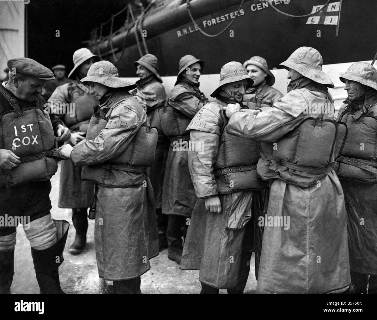 Lifeboatmen, die Flieger zu retten. Sheringham, Norfolk, Lifeboatmen Stand-by während operative Flüge über der Nordsee, Flieger, die in den "Drink" droppen können auf dem Weg nach außen oder Rückkehr zu retten. Diese Männer halten den Rekord für die Anzahl der Airmens Leben gerettet aus der Nordsee - 27 wurden gerettet. Das Rettungsboot ist bereit, auf das Meer an der Nachricht eines Momentes, Standby mit einem alert Crew, bis Entwarnung gegeben, und die Flieger fliegen über das Meer auf ihren Flugplatz gelandet. Januar 1944 P009198 Stockfoto